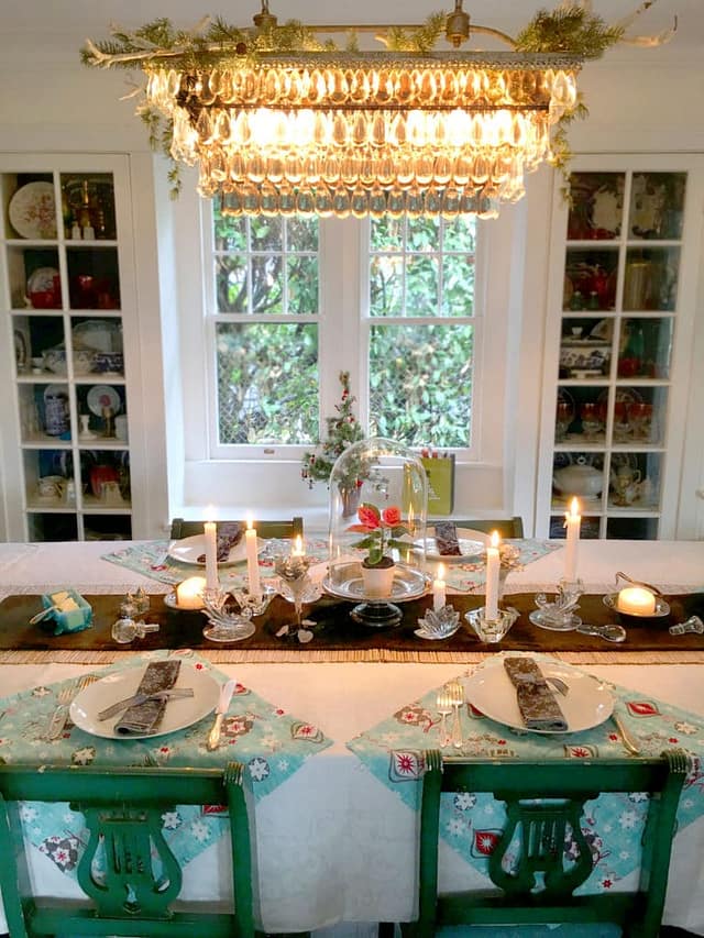 holiday table design with green chairs and chandelier